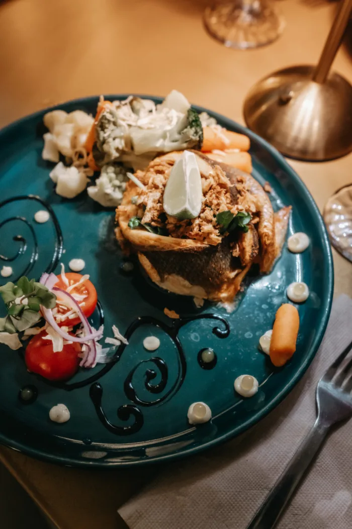 Lombo de bacalhau com broa e legumes, em prato verde