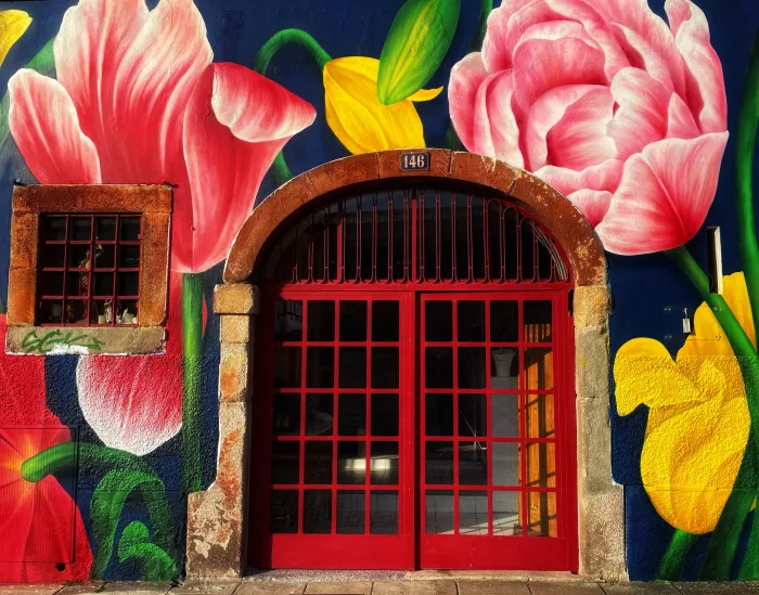 L’entrée du restaurant : porte rouge au numéro 146, sous une fresque de fleurs peinte sur la façade