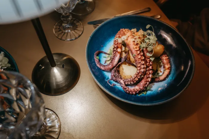Polvo assado com batata a murro, em prato azul