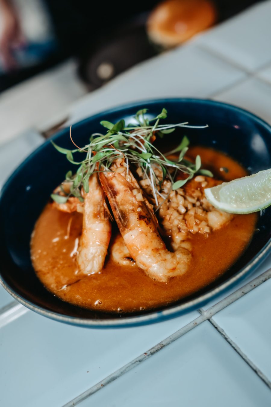 Gambas au riz crémeux et une rondelle de citron vert, dans une assiette bleue