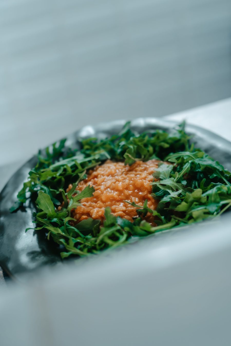 Risotto servi dans une couronne de roquette, dans une assiette de pierre