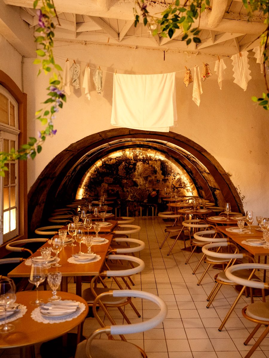 La salle de pierre voûtée, tables dressées et verres levés